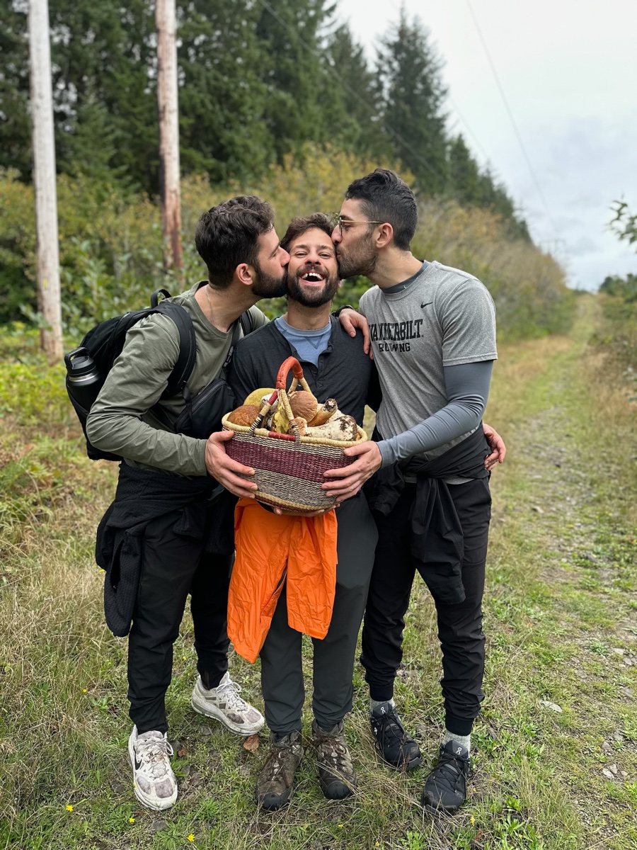 Zachary and friends sharing a laugh with a basket of foraged mushrooms